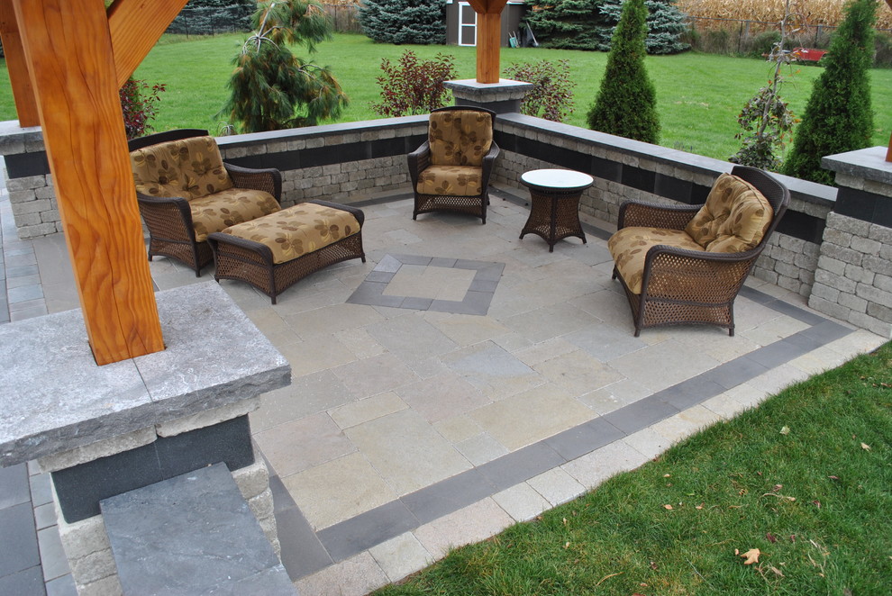 Ejemplo de patio de estilo americano grande en patio trasero con brasero, adoquines de piedra natural y cenador