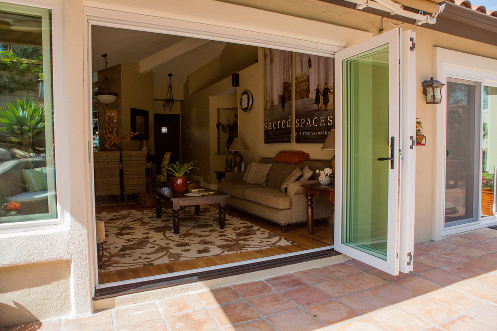 Medium sized contemporary back patio in Orange County with a fire feature, tiled flooring and an awning.
