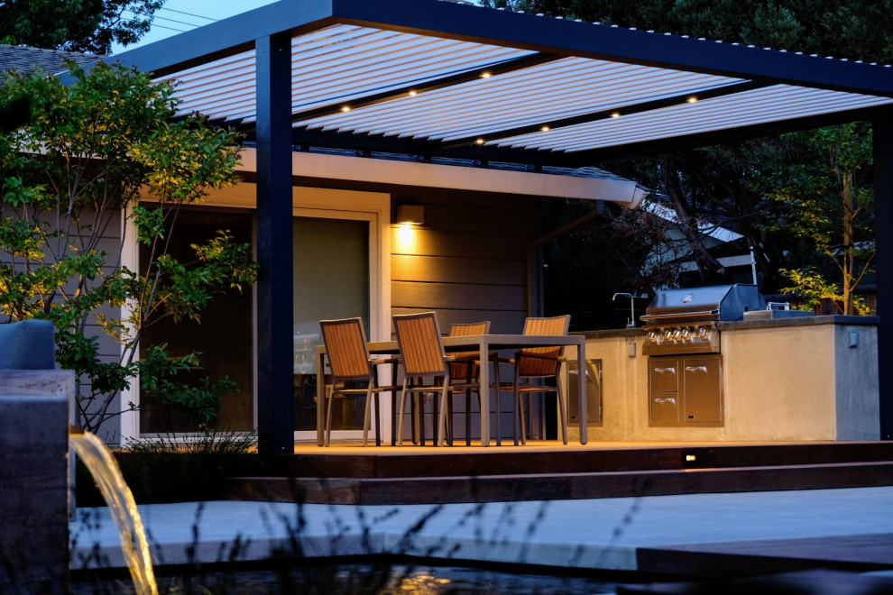 Exemple d'une terrasse arrière tendance de taille moyenne avec une cuisine d'été et une pergola.