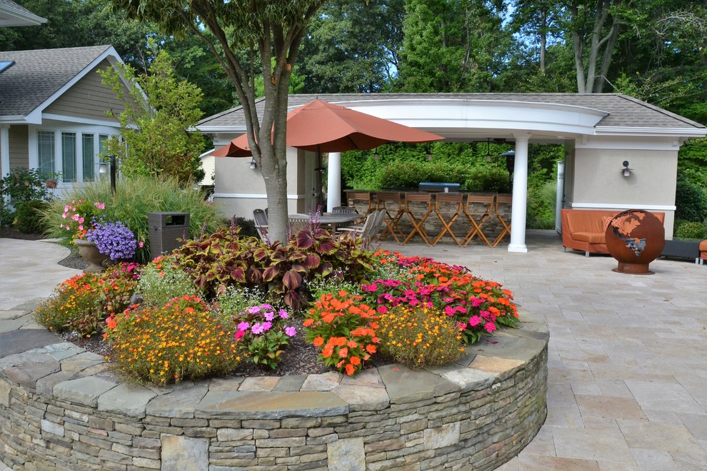 Design ideas for a large world-inspired back patio in New York with an outdoor kitchen, natural stone paving and a pergola.