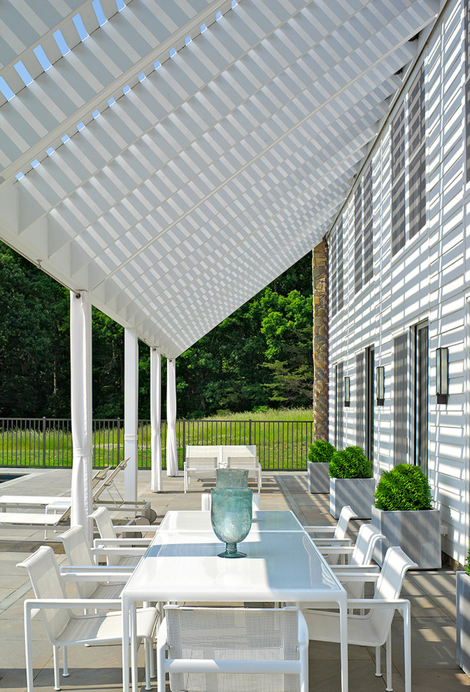 Patio - modern stone patio idea in Richmond with a pergola