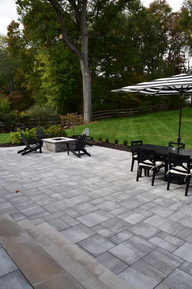 Foto de patio clásico renovado de tamaño medio sin cubierta en patio trasero con brasero y adoquines de hormigón