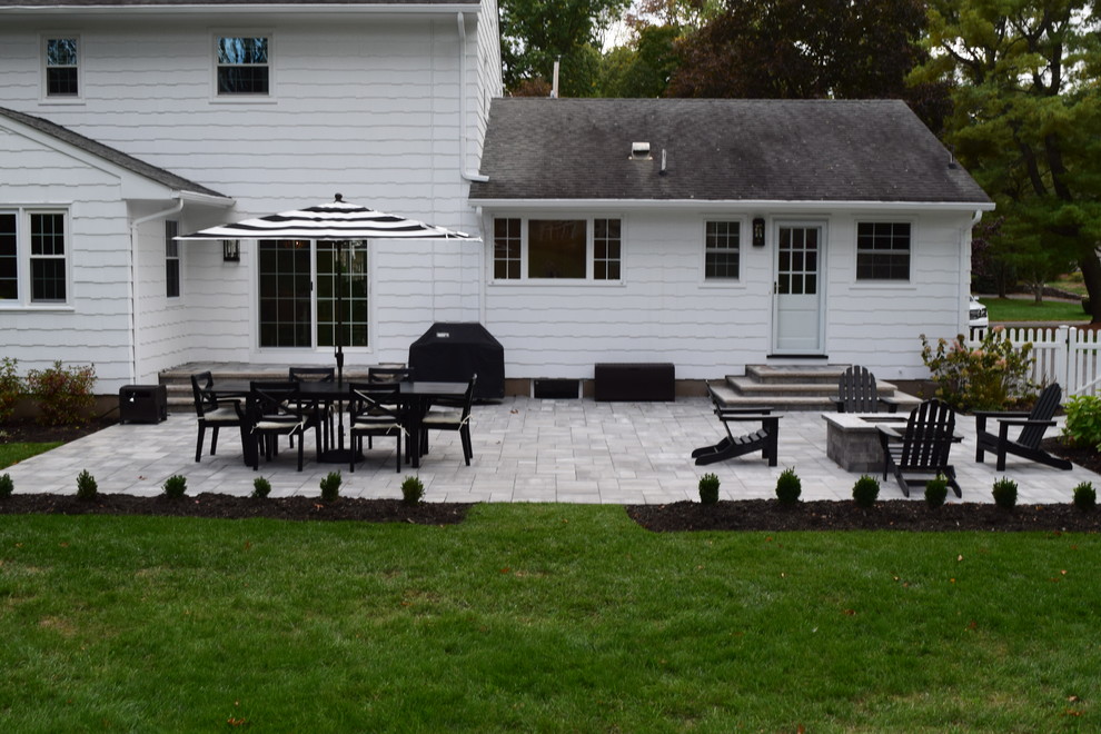 Foto di un patio o portico chic di medie dimensioni e dietro casa con un focolare, pavimentazioni in cemento e nessuna copertura
