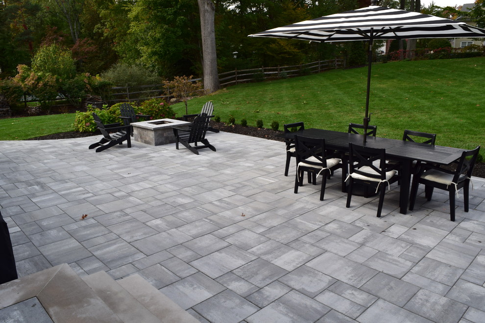 Example of a mid-sized transitional backyard concrete paver patio design in New York with a fire pit and no cover