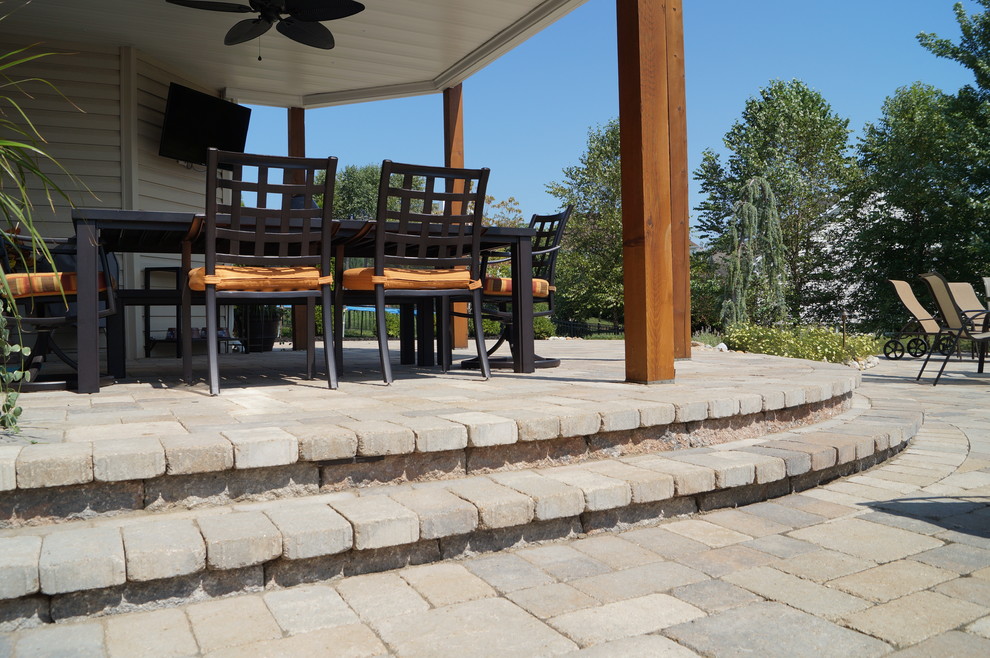 Patio - large traditional backyard stone patio idea in St Louis