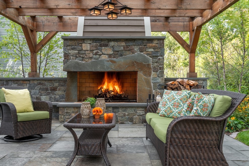 Diseño de patio clásico grande en patio trasero con adoquines de piedra natural, chimenea y pérgola