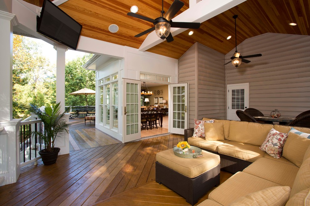 Imagen de patio clásico grande en patio trasero y anexo de casas con entablado