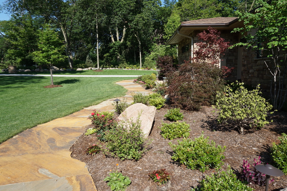 Réalisation d'un jardin arrière tradition de taille moyenne avec des pavés en pierre naturelle.