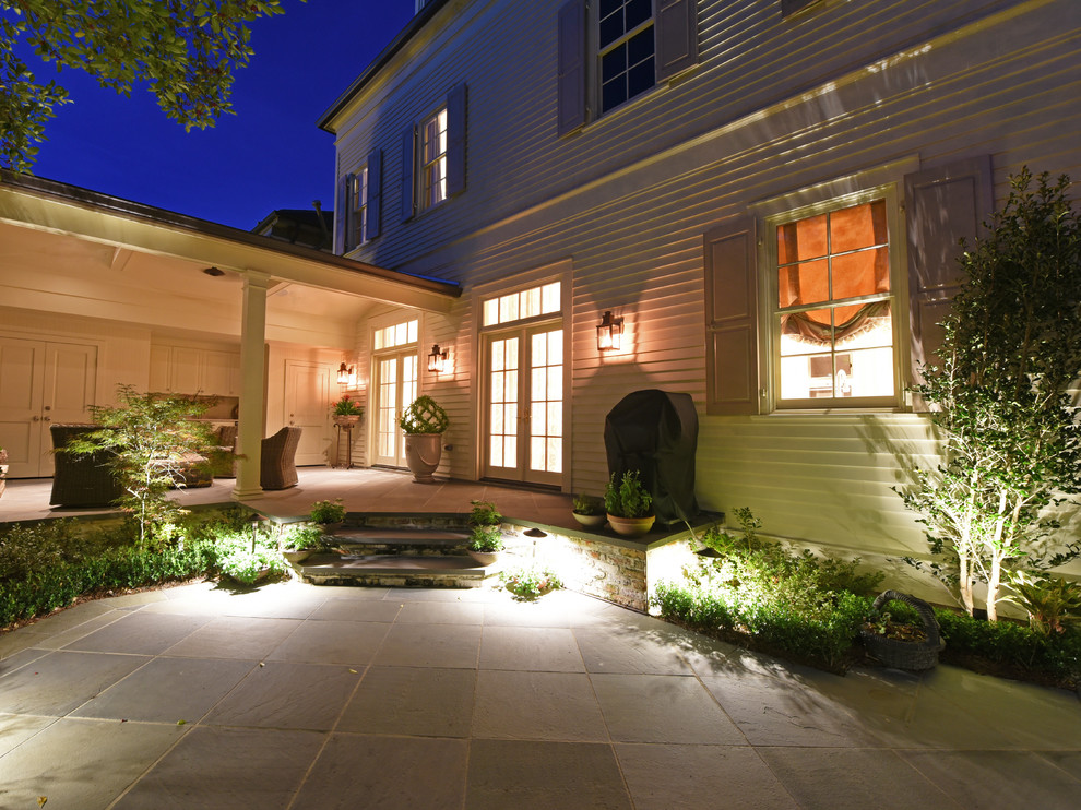 Exemple d'une grande terrasse arrière chic avec une cuisine d'été, des pavés en béton et une extension de toiture.