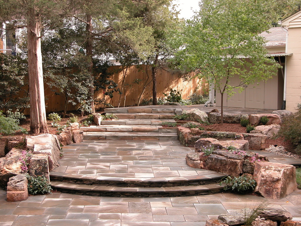 Cette image montre une grande terrasse arrière design avec un point d'eau et des pavés en pierre naturelle.