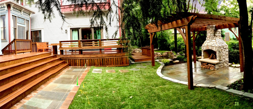 Mid-sized transitional backyard stone patio photo in Chicago with a fire pit and a pergola