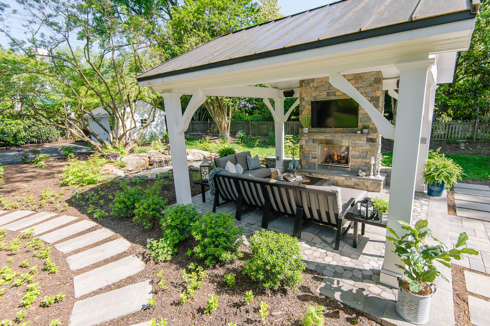 This is an example of a large traditional back patio in Richmond with a fireplace, concrete paving and a gazebo.