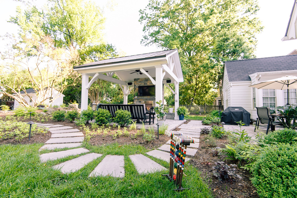 Foto di un grande patio o portico chic dietro casa con un caminetto, pavimentazioni in cemento e un gazebo o capanno