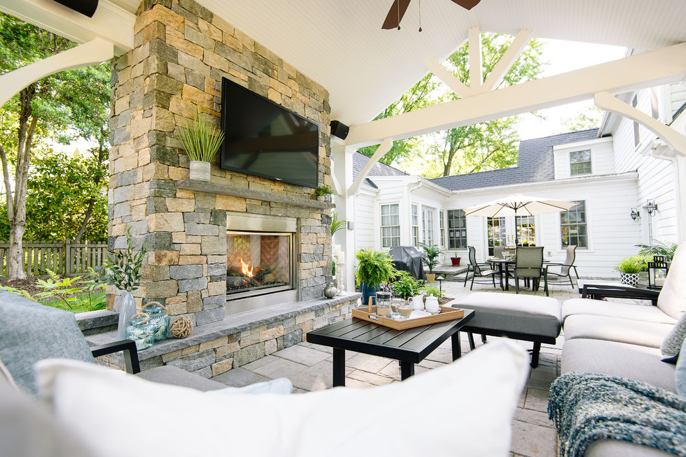 Imagen de patio clásico grande en patio trasero con chimenea, adoquines de hormigón y cenador