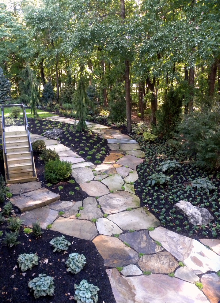 Immagine di un ampio giardino tradizionale dietro casa con pavimentazioni in pietra naturale