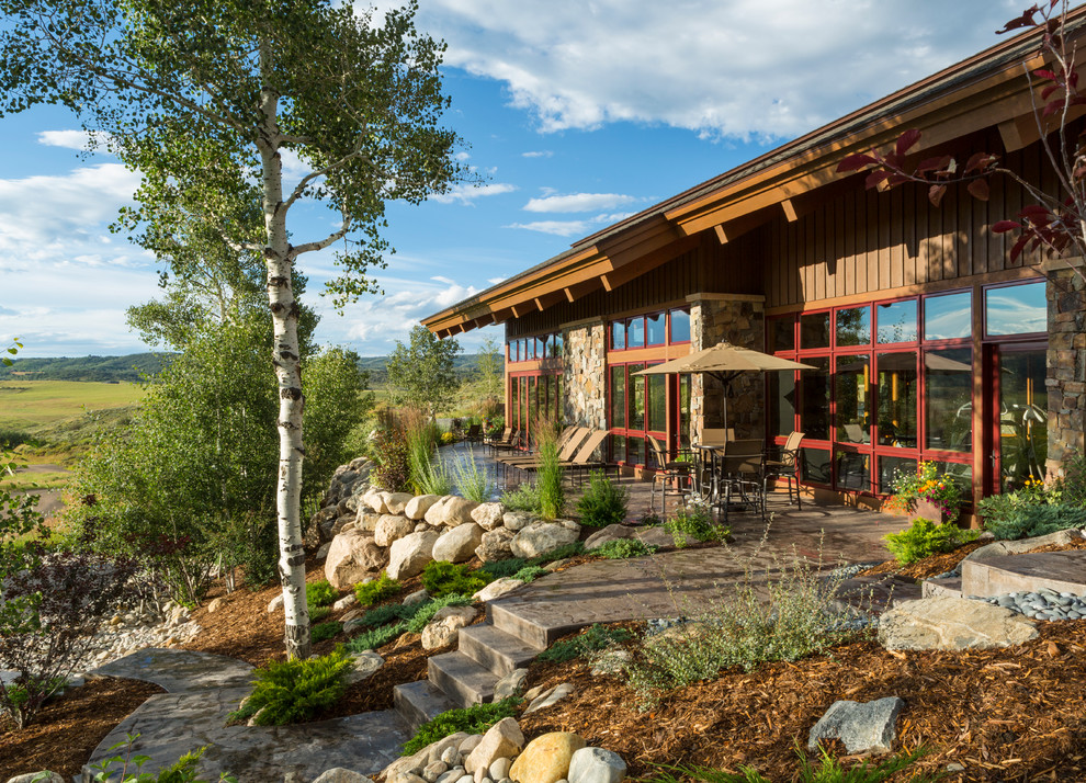 Inspiration for a large rustic back patio in Denver with stamped concrete and no cover.