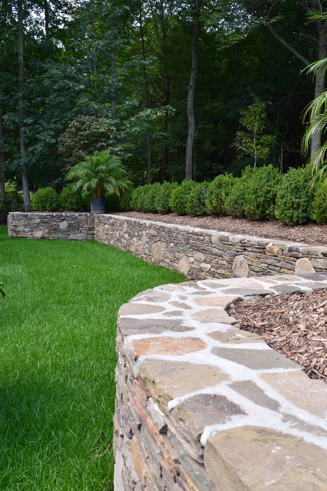 This is an example of a medium sized rustic back garden in New York with a water feature and natural stone paving.