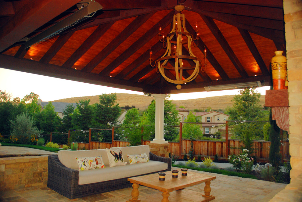 Imagen de patio mediterráneo de tamaño medio en patio trasero con brasero, adoquines de piedra natural y cenador