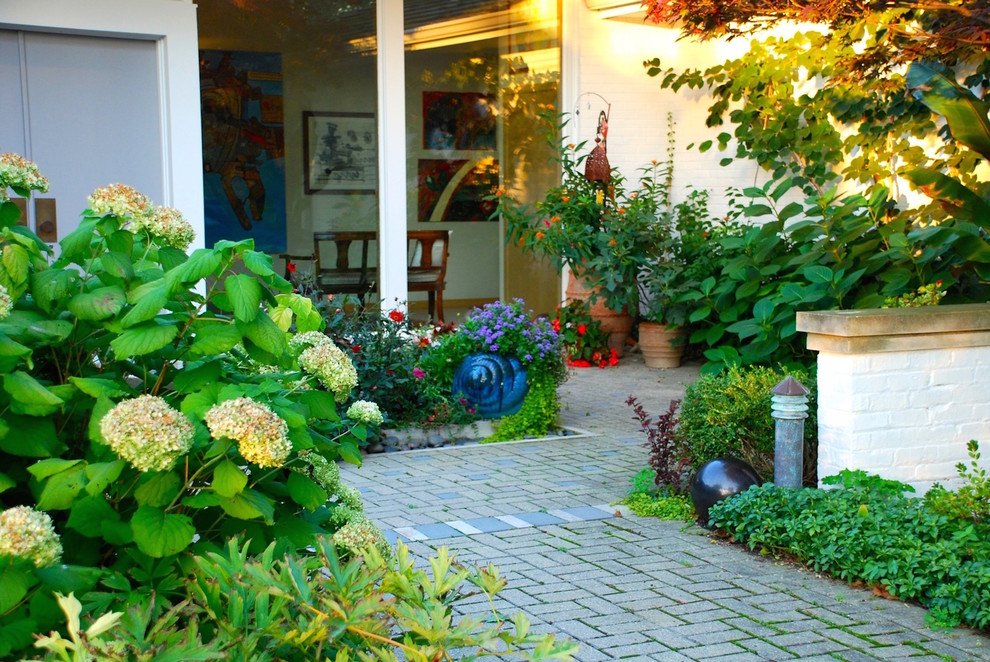 This is an example of a small eclectic front patio in Chicago with a potted garden, concrete paving and no cover.