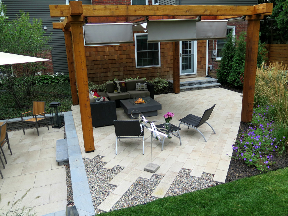 Immagine di un patio o portico minimal di medie dimensioni e dietro casa con un focolare, ghiaia e una pergola