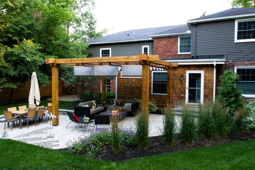 Immagine di un patio o portico contemporaneo di medie dimensioni e dietro casa con un focolare, ghiaia e una pergola