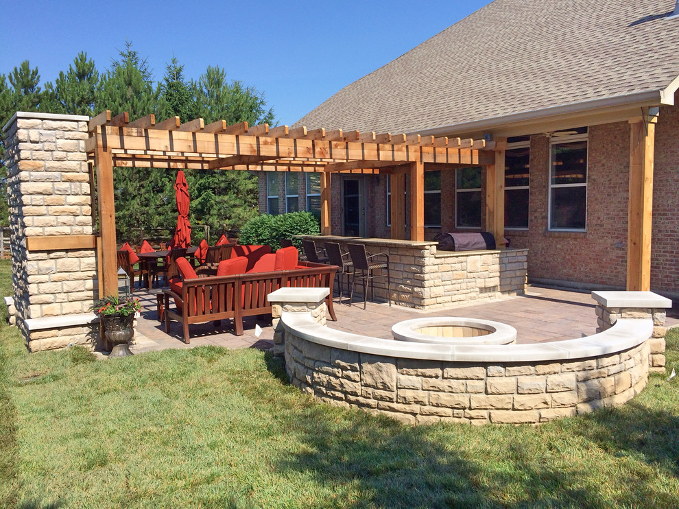 Patio - large cottage backyard concrete paver patio idea in Cincinnati with a fire pit and a pergola