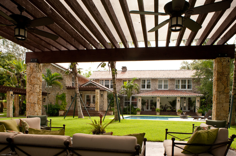 Foto de patio tropical extra grande en patio trasero con cocina exterior, losas de hormigón y pérgola