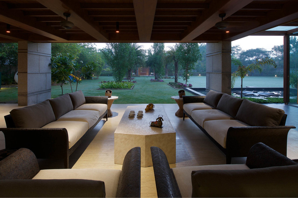 Inspiration pour une grande terrasse arrière minimaliste avec un point d'eau, un gravier de granite et une extension de toiture.