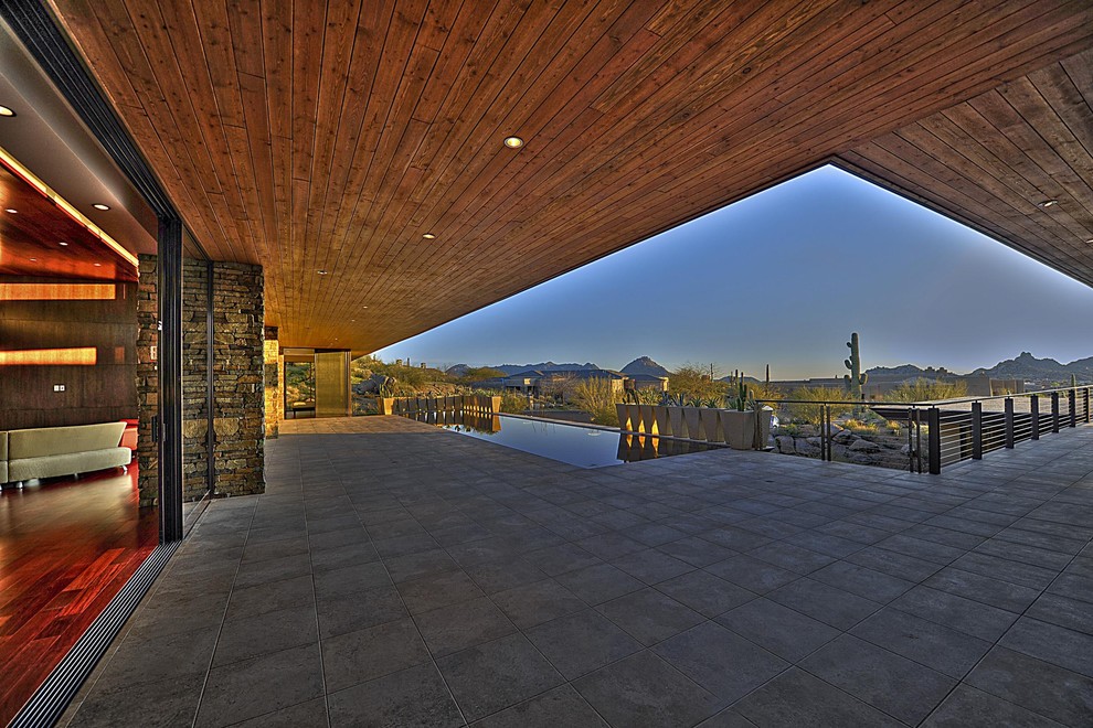 Immagine di un grande patio o portico design dietro casa con un tetto a sbalzo