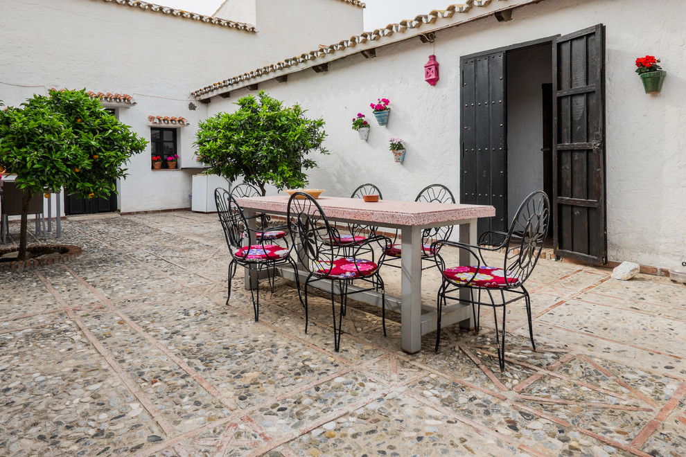 Imagen de patio mediterráneo grande sin cubierta en patio con jardín vertical y adoquines de piedra natural