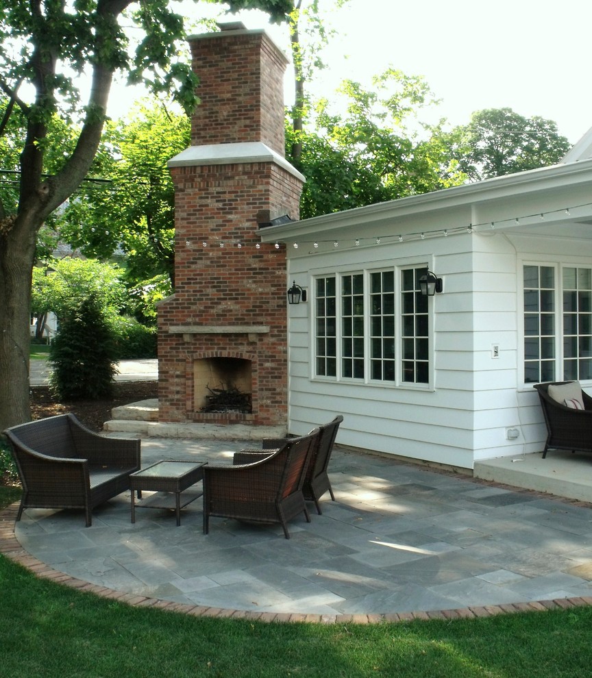 Ejemplo de patio tradicional de tamaño medio sin cubierta en patio trasero con brasero y adoquines de piedra natural