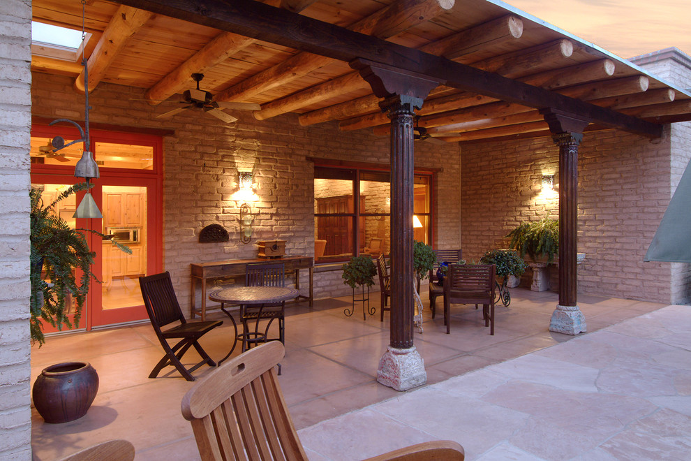 Esempio di un grande patio o portico stile rurale dietro casa con cemento stampato e un tetto a sbalzo