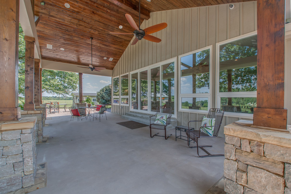 Expansive farmhouse back patio in Nashville with natural stone paving and a roof extension.