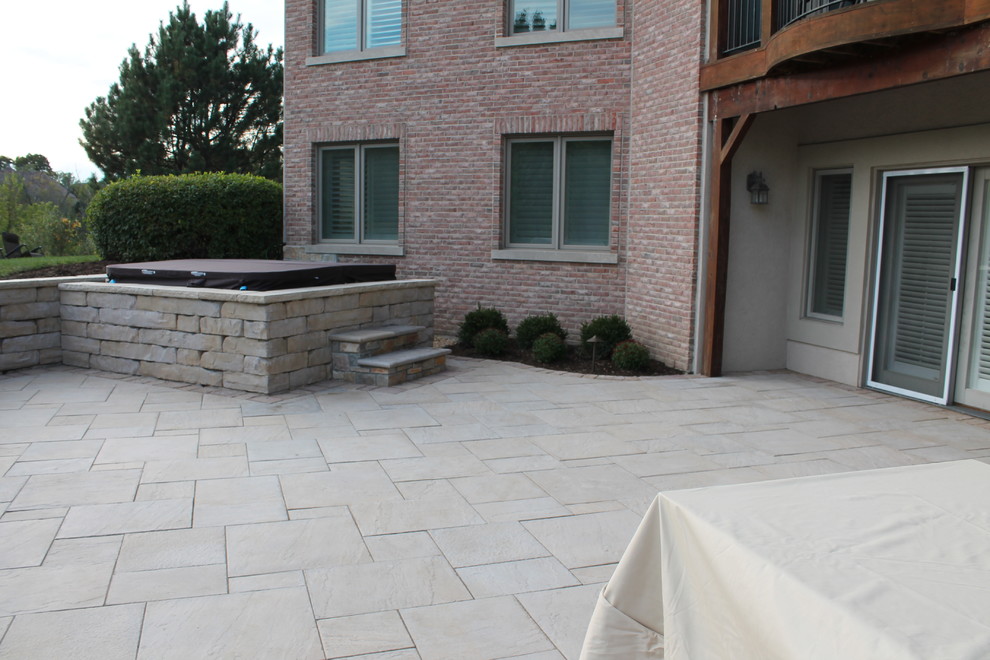 This is an example of a medium sized contemporary back patio in Chicago with concrete paving and no cover.