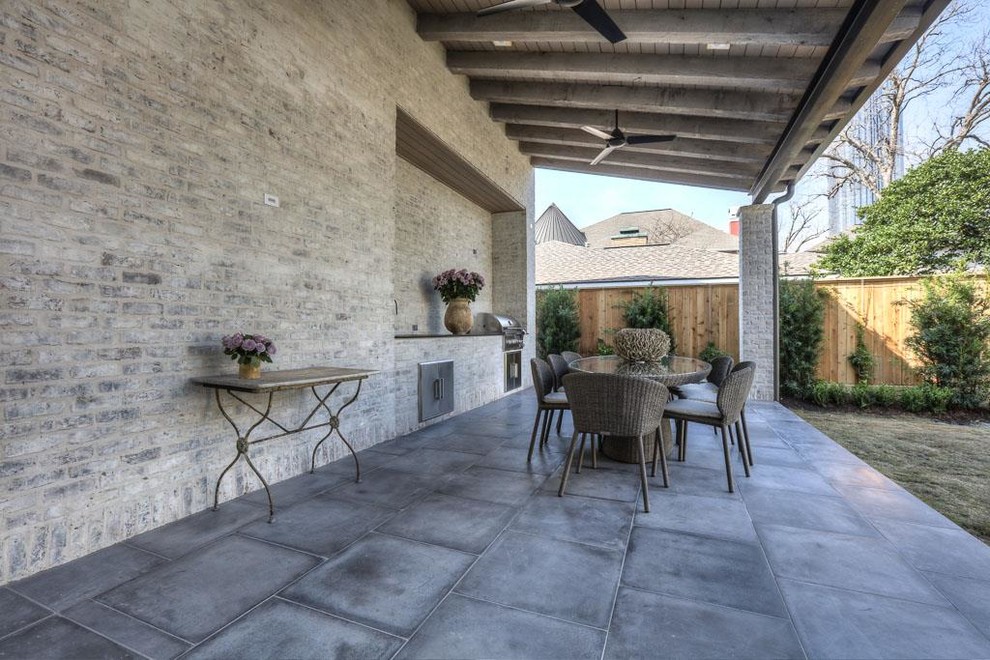 Example of a mid-sized transitional backyard concrete paver patio kitchen design in Houston with a roof extension