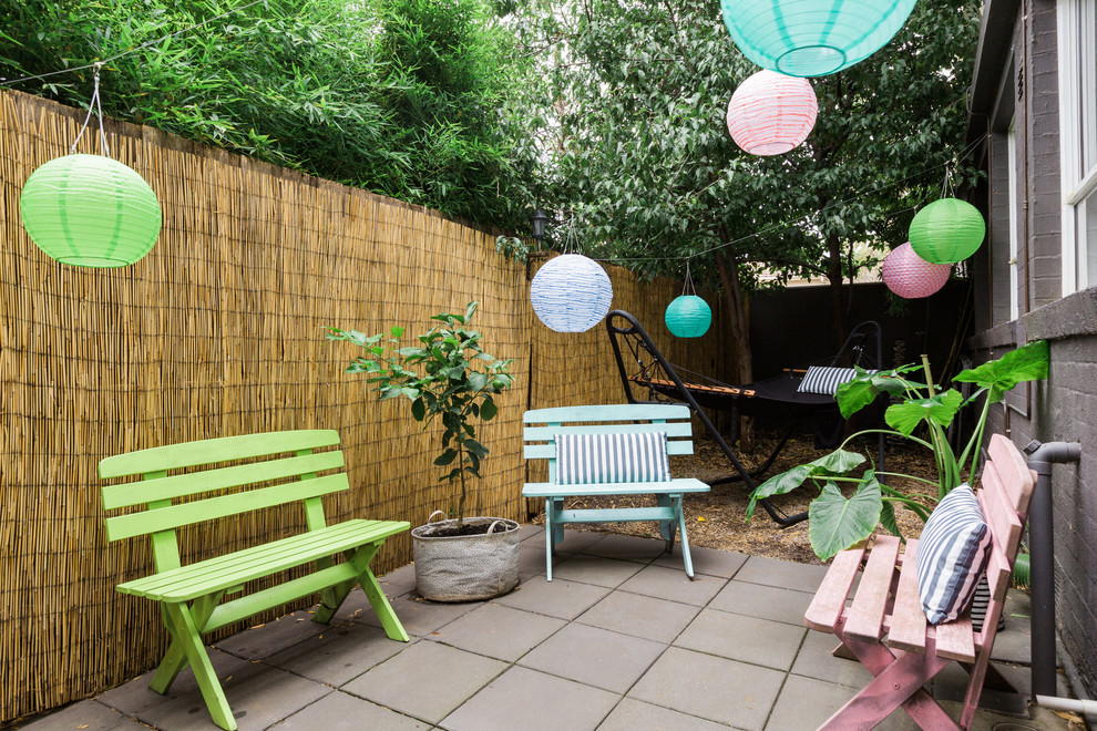 Medium sized eclectic courtyard patio in Melbourne with a potted garden, concrete paving and no cover.