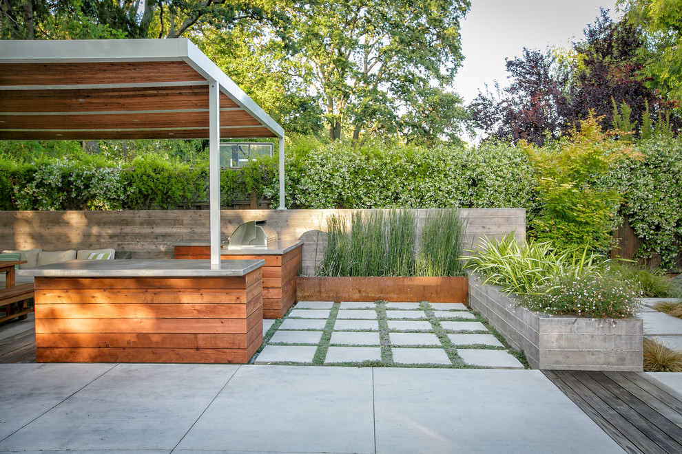 Large contemporary back patio in San Francisco with an outdoor kitchen and concrete paving.