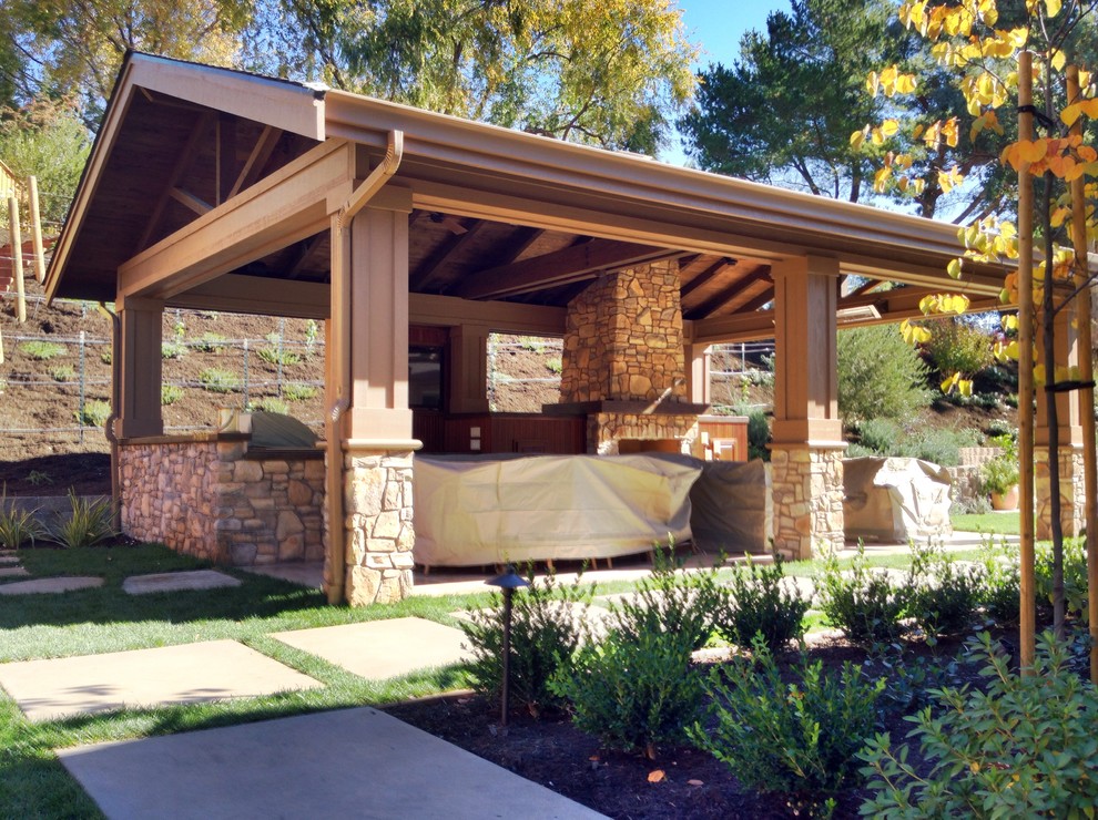Modelo de patio de estilo americano grande en patio trasero con pérgola, brasero y adoquines de piedra natural