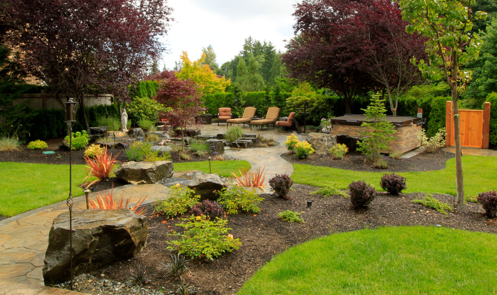 На фото: большой участок и сад на заднем дворе в современном стиле с покрытием из каменной брусчатки с