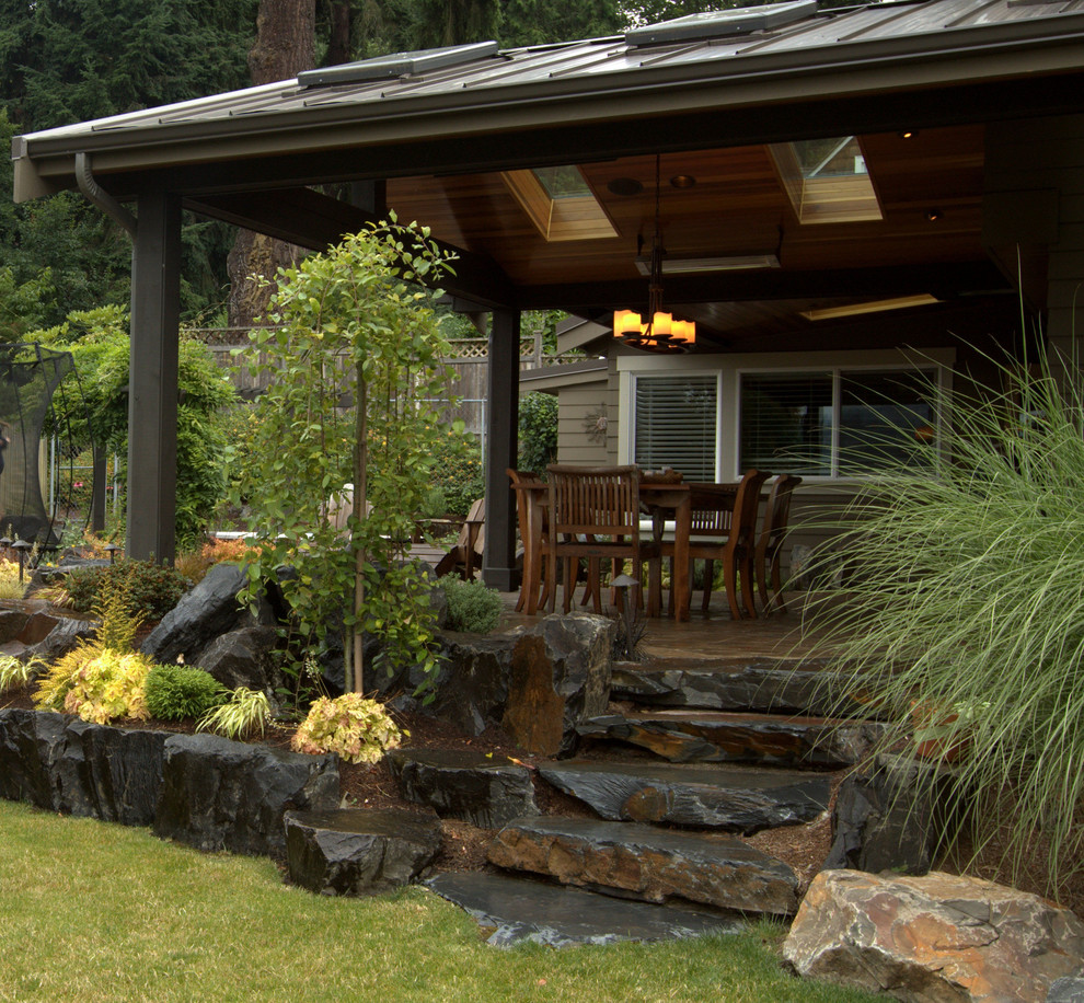 Exemple d'une terrasse arrière tendance avec un foyer extérieur et des pavés en pierre naturelle.