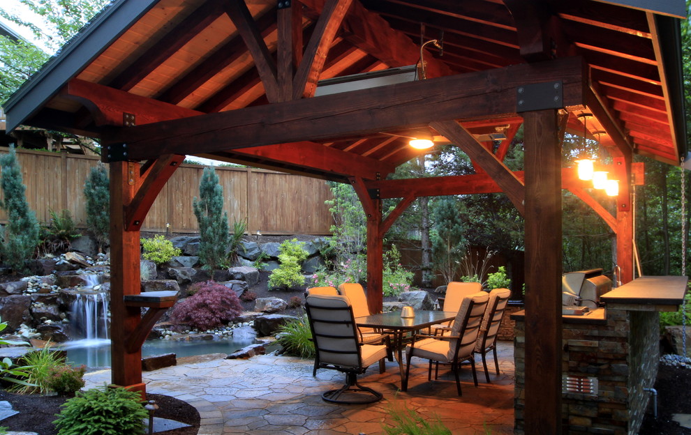 Diseño de patio actual grande en patio trasero con adoquines de piedra natural, cocina exterior y cenador
