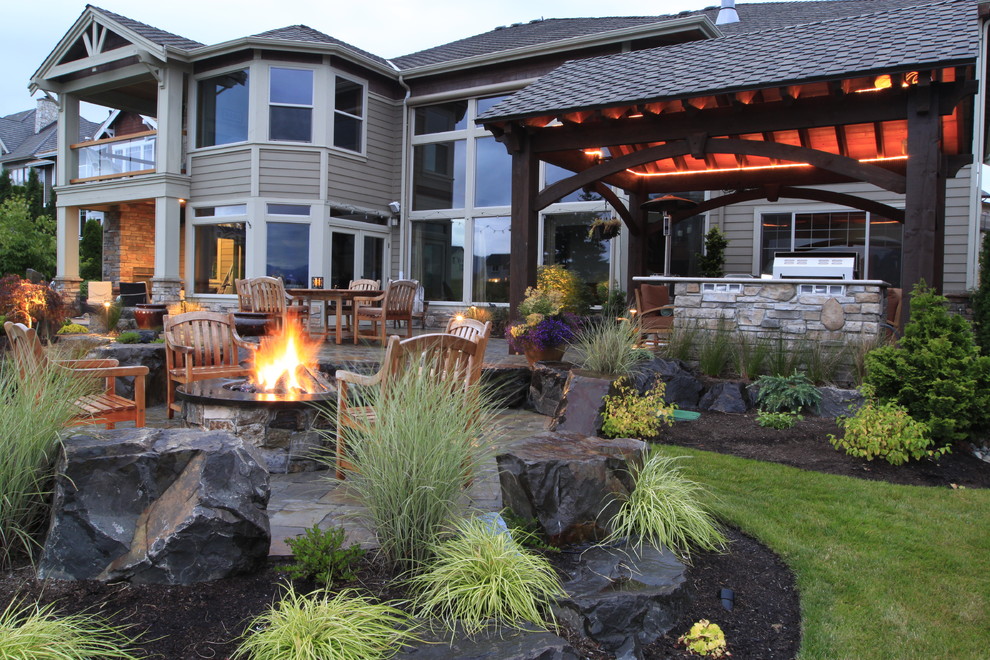 Imagen de patio contemporáneo grande en patio trasero con brasero, adoquines de piedra natural y cenador