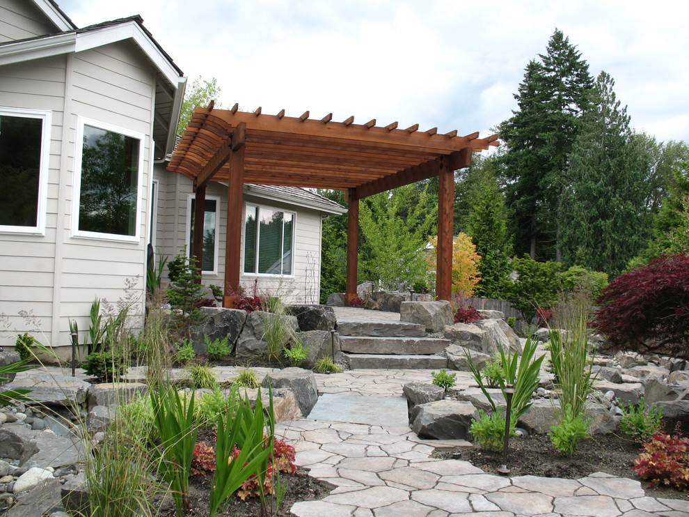 Diseño de patio clásico en patio trasero con brasero y adoquines de piedra natural