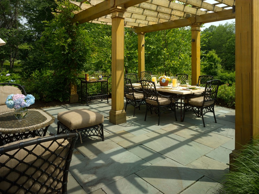 Aménagement d'une terrasse avec des plantes en pots classique de taille moyenne avec des pavés en béton et une pergola.