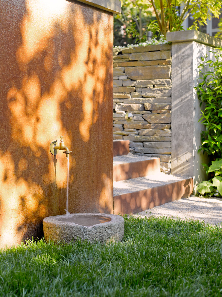 Example of a trendy backyard decomposed granite patio design in Seattle with no cover