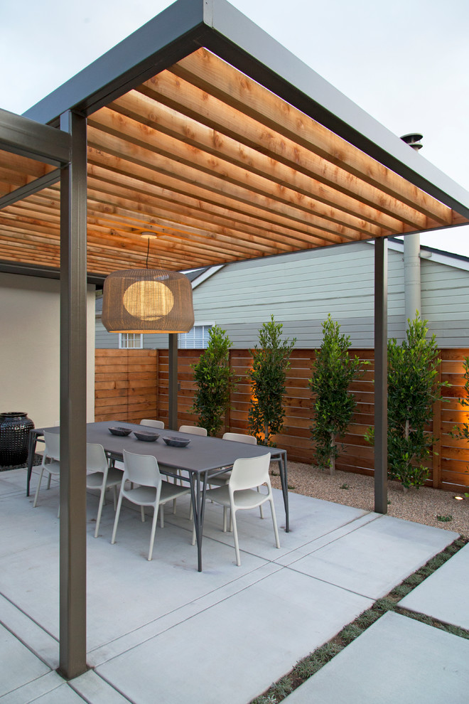 На фото: большая пергола во дворе частного дома на заднем дворе в стиле модернизм с летней кухней и покрытием из бетонных плит
