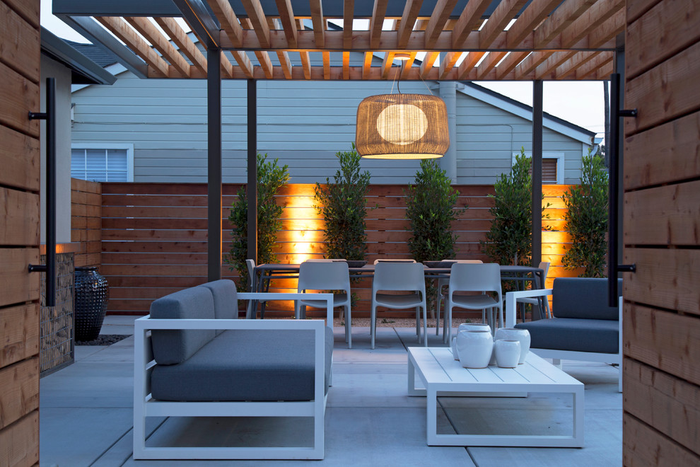 Example of a large minimalist backyard concrete patio kitchen design in San Luis Obispo with a pergola