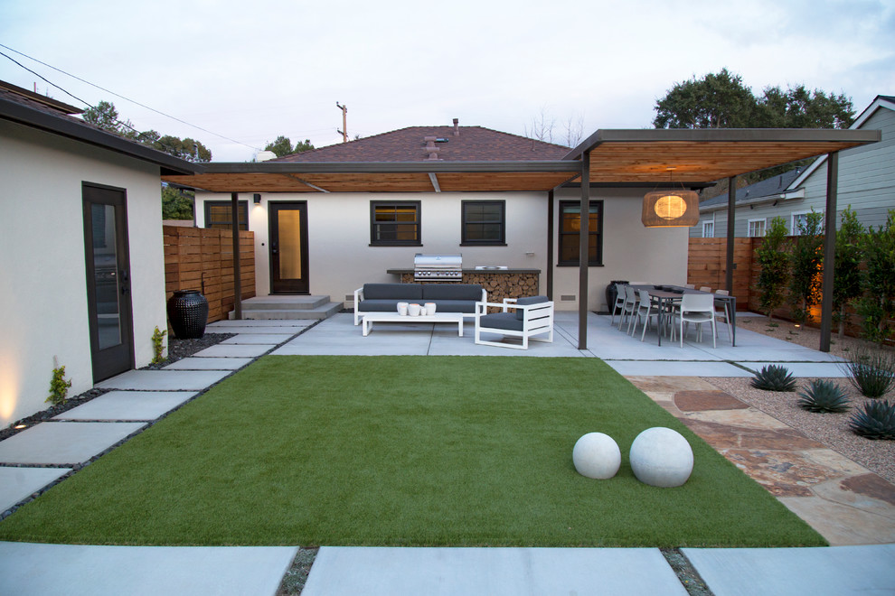 Imagen de patio moderno grande en patio trasero con cocina exterior, losas de hormigón y pérgola