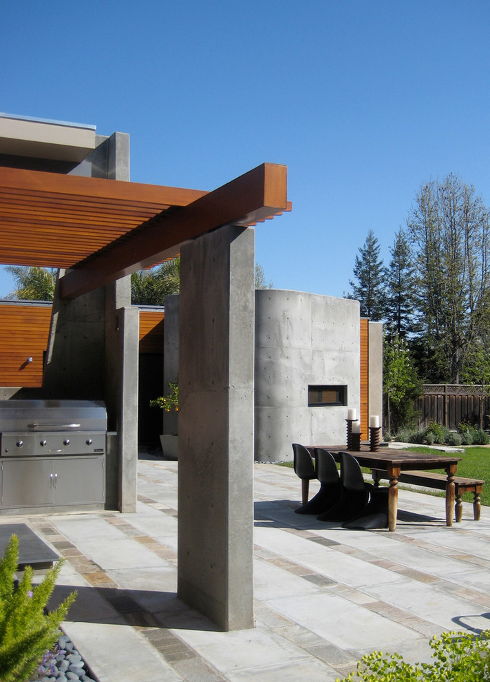 На фото: двор на заднем дворе в современном стиле с зоной барбекю с