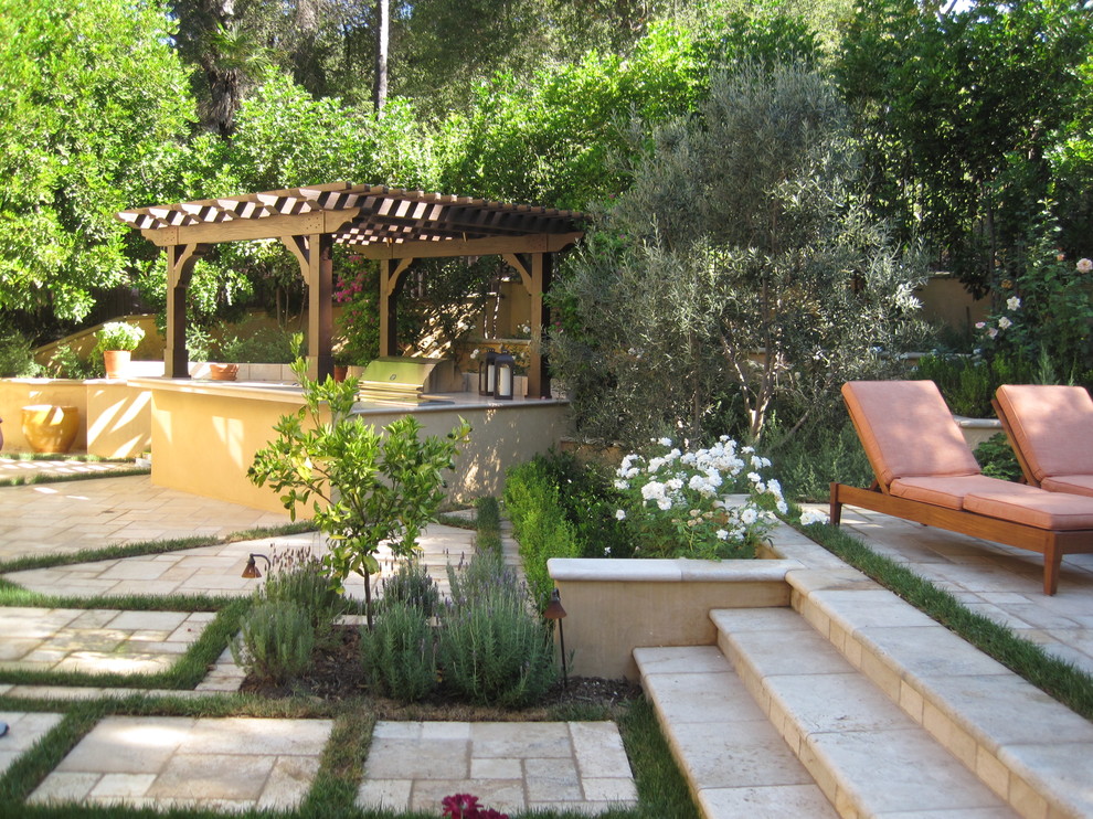 Réalisation d'une terrasse méditerranéenne avec une cuisine d'été et une pergola.